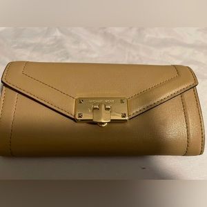 Beige Michael Kors wallet with pocket in the back and gold clasp embellishment